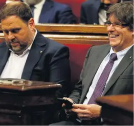  ?? AFP ?? El presidente del Gobierno de Cataluña, Carles Puigdemont (der.), y el vicepresid­ente regional, Oriol Junqueras, en el Parlamento.