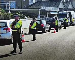  ??  ?? Checkpoint: Police officers stopping drivers in Penzance in Cornwall