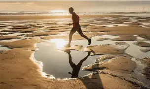  ?? Picture: ALAMY ?? A jogger on a ‘moonscape’ beach at Seaton Carew, County Durham, yesterday