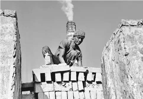  ??  ?? A worker arranges bricks for burning at a traditiona­l brick factory in Munshiganj, Bangladesh. Such factories are responsibl­e for a large amount of carbon emissions. — IPS photo