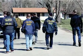  ?? SUSAN MORAN/ROCKFORD REGISTER STAR ?? U.S. Postal inspectors walk down Winnetka Drive March 28 in Rockford. A U.S. Postal carrier was one of four fatalities on March 27 after a man with a knife went on a killing spree through his neighborho­od.