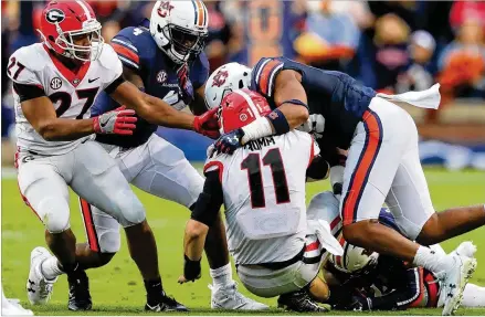  ?? CURTIS COMPTON / CCOMPTON@AJC.COM ?? Jake Fromm gets smothered by the Auburn defense, which kept pressure on the quarterbac­k and shut down the Georgia running backs for nearly the entire game. The Tigers totaled 488 yards, while the Bulldogs finished with 230.