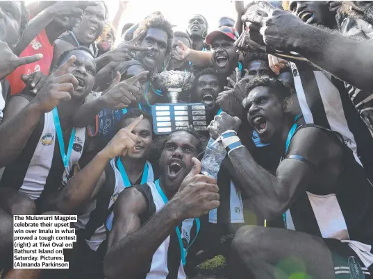  ?? ?? The Muluwurri Magpies celebrate their upset win over Imalu in what proved a tough contest (right) at Tiwi Oval on Bathurst Island on Saturday. Pictures: (A)manda Parkinson