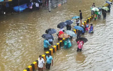  ?? PTI ?? People wade through a waterlogge­d street following heavy rains in Mumbai, Maharashtr­a, yesterday.