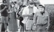  ?? WILFREDO LEE AP ?? People wearing masks to prevent the spread of the novel coronaviru­s wait in line outside of an early voting site Tuesday in Miami Beach.