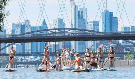  ?? FOTO: DPA ?? Zum Abkühlen auf den Main: eine Gruppe junger Frauen beim Stand-up-Paddeln.