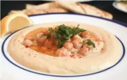  ??  ?? Hummus masabacha finds creamy hummus tehina topped with semi-mashed, warm chickpeas. Hummus has been eaten in the Middle East for centuries.