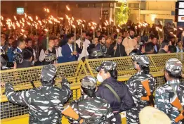  ?? — PTI ?? Security personnel stop activists of the All Assam Students’ Union staging a torch rally to protest against the Citizenshi­p Amendment Act in Guwahati on Friday.