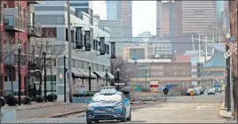  ?? [KEITH SRAKOCIC/THE ASSOCIATED PRESS] ?? An Argo AI autonomous vehicle navigates Pittsburgh’s industrial “Strip District,” where the city draws lines across the streets’ narrow lanes to mark where vehicles should stop for stop signs. Sometimes autonomous cars that stop at the lines can’t see traffic on the cross street.