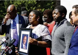  ?? ASSOCIATED PRESS ?? Caroline Ouko, mother of Irvo Otieno, holds a portrait of her late son with attorney Ben Crump (left), older son Leon Ochieng and attorney Mark Krudys at the Dinwiddie Courthouse in Dinwiddie, Virginia, on Thursday.