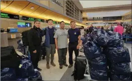  ?? Photo courtesy of Joseph White ?? Joseph White, Jake Dai, Charles Yeh and James Lee pose for a picture with the supplies from Henry Mayo Newhall Hospital in tow at the Tom Bradley Internatio­nal terminal at LAX.