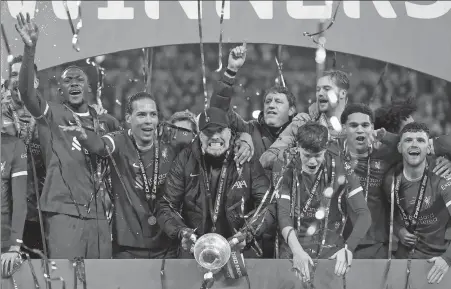  ?? Below: REUTERS ?? Liverpool manager Jurgen Klopp and his players celebrate winning the English League Cup after beating Chelsea 1-0 in Sunday’s final at Wembley Stadium in London. Virgil van Dijk watches as his header flies past Chelsea goalkeeper Djordje Petrovic.