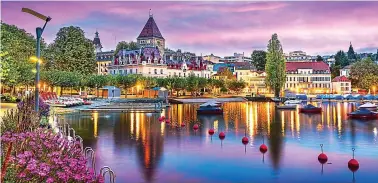  ?? ?? Splendour: Lausanne viewed from the Ouchy Promenade on Lake Leman at twilight