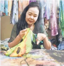  ?? ?? Thuc cu ing a piece of fabric for an artwork.