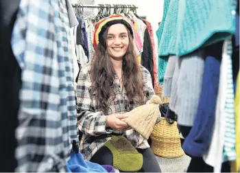  ?? PHOTO: GREGOR RICHARDSON ?? If the cap fits . . . Bianca Keane, of Dunedin, picks up some essentials for free at the St Vincent de Paul shop in South Dunedin yesterday.