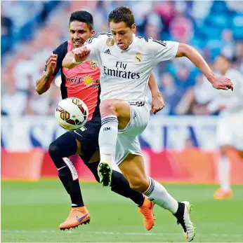  ??  ?? Real Madrid forward Javier Hernandez (right) vies with Almeria defender Mauro Javier dos Santos during their Spanish league match at the Santiago Bernabeu stadium in Madrid on Wednesday. Real won 3-0.