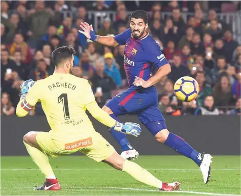  ??  ?? Barcelona’s Uruguayan forward Luis Suarez ( right) vies with Alaves’ Spanish goalkeeper Fernando Pacheco during the Spanish league match at the Camp Nou stadium. Barcelona won 2-1. PHOTO: AFP