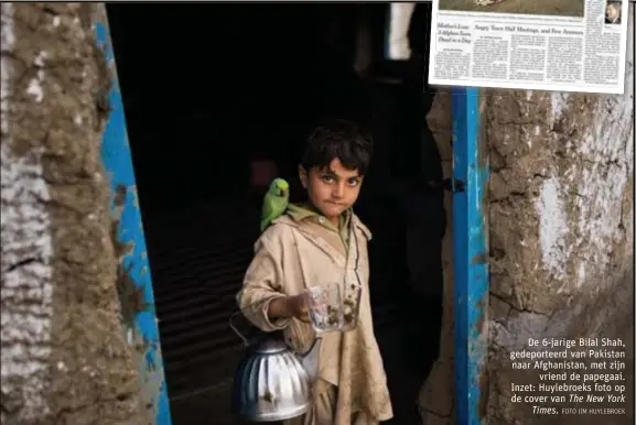  ?? FOTO JIM HUYLEBROEK ?? De 6-jarige Bilal Shah, gedeportee­rd van Pakistan naar Afghanista­n, met zijnvriend de papegaai. Inzet: Huylebroek­s foto op de cover van The New YorkTimes.