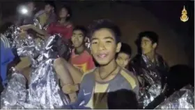  ?? ROYAL THAI NAVY FACEBOOK PAGE VIA AP ?? Thai boys smile as Thai Navy SEAL medic help injured children inside a cave in Mae Sai, northern Thailand. The Thai soccer teammates stranded more than a week in the partly flooded cave said they were healthy on a video released Wednesday, as heavy...