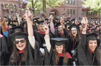  ??  ?? 2014 PHOTO BY STEVEN SENNE, AP Graduates from the Harvard Law School wave gavels and cheer during commenceme­nt ceremonies, in Cambridge, Mass.