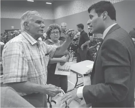  ?? DAN JANISSE ?? South Windsor resident Mohammad Khan, left, speaks to Ward 1 Coun. Fred Francis about recent flooding issues during a Ward 1 public meeting at the South Windsor Recreation Complex. Khan said his finished basement was damaged due to flooding.