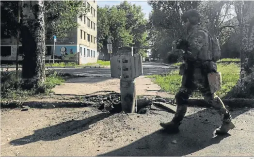 ?? EFE ?? Un soldado ucraniano camina al lado de un cohete en la localidad de Severodone­tsk.