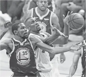 ??  ?? Warriors forward Kevin Durant battled the Raptors, including center Serge Ibaka, early in Monday’s game in his first game since May 8. KYLE TERADA/USA TODAY SPORTS