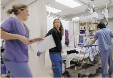  ??  ?? Medical staff assist a patient at Vancouver General Hospital during filming of the first season of Emergency Room: Life and Death at VGH.