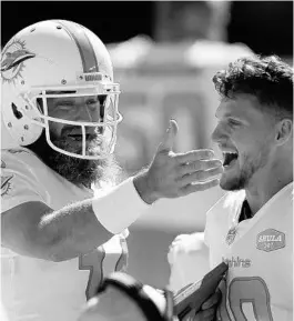  ?? JED JACOBSOHN/AP ?? Dolphins quarterbac­k Ryan Fitzpatric­k, left, celebrates with receiver Adam Shaheen on the sideline during Sunday’s victory at San Francisco.