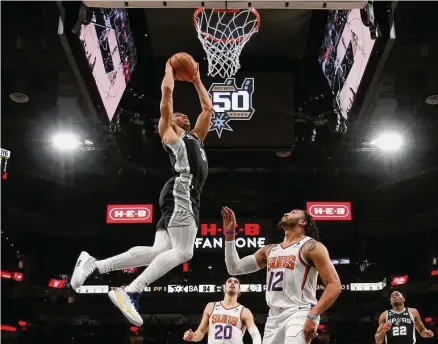  ?? Ronald Cortes / Contributo­r/ ?? Spurs forward Keldon Johnson dunks against Ish Wainright of Phoenix during Sunday’s game at the AT&T Center. Johnson had 27 points against the Suns, after a November where he made only 83 of 231 field attempts, including 35 of 110 3-point tries.