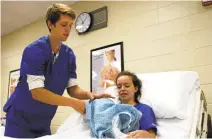  ?? CARRIE ANTLFINGER/ASSOCIATED PRESS ?? Nathan Miller, 19, left, works with fellow student Camille Sem, 17, in a certified nursing assistant class at New Berlin Eisenhower Middle/High School in New Berlin, Wis. Miller hopes to attend medical school.