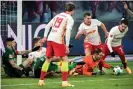  ??  ?? Leipzig’s former Liverpool goalkeeper Peter Gulacsi (bottom right) in action during the 2-1 victory over Augsburg on Friday. Photograph: Clemens Bilan/EPA