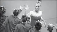  ?? NWA Democrat-Gazette/CHARLIE KAIJO ?? high-fives teammates after her performanc­e on the floor exercise in the Razorbacks’ victory Friday.