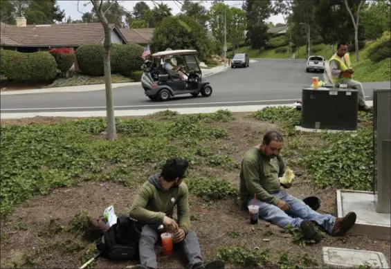 ?? GREGORY BULL — THE ASSOCIATED PRESS FILE ?? Duncan Wallace drives a golf cart from his house to his golf club as a group of landscape workers take a break in Vista, Calif. The United States is growing older and more ethnically diverse, a trend that is could put strains on government programs...