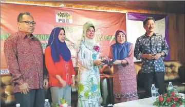  ??  ?? Zainanai (second right) presents a souvenir to Fatimah, witnessed by (from left) Ahmad Lai, Rosey and Ripin.