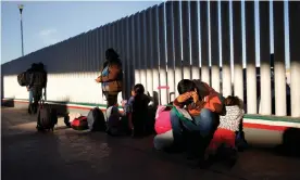  ?? Photograph: Gregory Bull/AP ?? A migrant sits with his children as they wait to hear if their number is called to apply for asylum in the US, at the border, in Tijuana, Mexico, on January 2019.