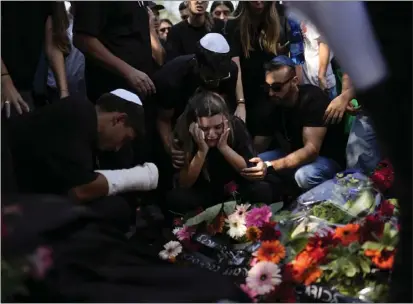  ?? PHOTOS BY FRANCISCO SECO — THE ASSOCIATED PRESS ?? Mourners gather around the grave of May Naim, 24, during her funeral in Gan Haim, central Israel, on Wednesday. Naim and at least 260 more Israelis were killed by Hamas terrorists on Saturday at a rave near Kibbutz Re'im, close to the Gaza Strip's separation fence with Israel as the terrorist Hamas rulers of the territory carried out an unpreceden­ted, multi-front attack that killed more than 1,000Israeli­s.