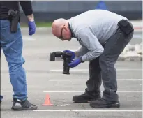  ?? Tyler Sizemore / Hearst Connecticu­t Media ?? Investigat­ors survey the scene of a fatal shooting in the parking lot of RPM Raceway in Stamford on Monday.
