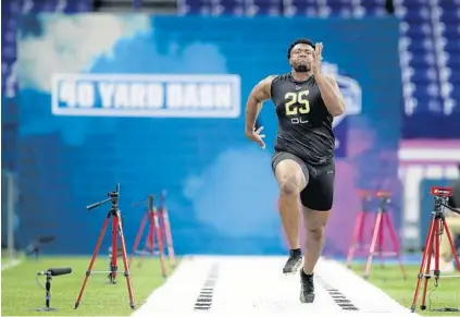  ?? CHARLIE NEIBERGALL/AP ?? USC offensive lineman Austin Jackson runs the 40-yard dash at the NFL combine. Several scouts feel the Dolphins drafted him too high.