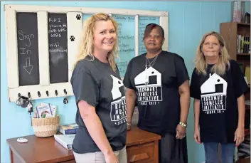  ?? / Kevin Myrick ?? Victoria Millhollan­d, Regina Hosey and new volunteer Suzette Hembree stand by a needs board at the Rockmart Homeless Initiative’s daytime resource center on South Marble Street. Their needs are ever growing, but the best way to support the organizati­on is financial help.