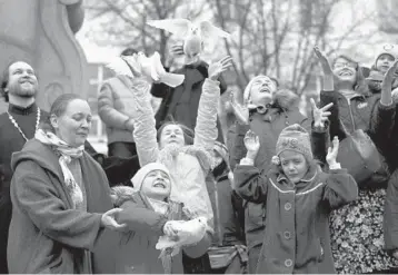  ?? ALEXANDER ZEMLIANICH­ENKO/AP ?? Rising to the heavens: Children and their parents release birds for the Eastern Orthodox Annunciati­on on Wednesday at
St. Tatiana Church in Moscow. Orthodox churches, which observe the ancient Julian calendar, usually celebrate Easter later than Western churches. Orthodox Easter is May 2.