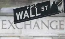  ?? REUTERSPIX ?? The Wall Street sign outside the New York Stock Exchange. M&As have reached 40,000 deals this year.