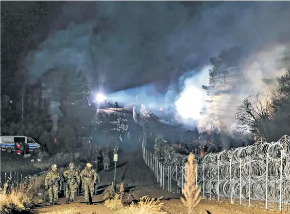  ?? ?? Polish soldiers at the frontier as migrants gather at Kuznica Bialostock­a and (below) refugees in Grodno