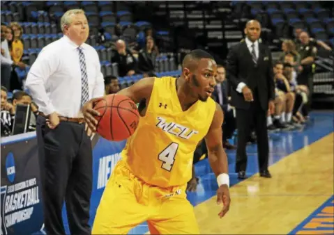  ?? PHOTO COURTESY WCU ?? West Chester University’s Jawan Collins dribbles around the perimiter Saturday as his coach Damien Blair, far background, looks on against WheelingJe­suit at Virginia State.