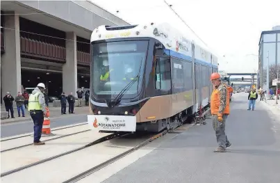  ?? MIKE DE SISTI/MILWAUKEE JOURNAL SENTINEL ?? The streetcar makes its way on the track after being unloaded from the flatbed truck Monday in downtown Milwaukee.