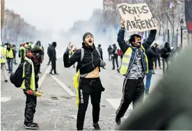  ??  ?? Integrante­s de los “chalecos amarillos” protestan en París.