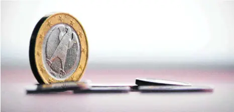  ?? FOTO: NICOLAS ARMER/DPA ?? Eine Euro-Münze liegt auf einem farbigen Papier. Die Erfahrung mit extremer Lockerung der Geldpoliti­k zeigt, dass viel Geldangebo­t bei hohem Warenangeb­ot und Konkurrenz der Anbieter nicht zu steigenden Preisen führt.