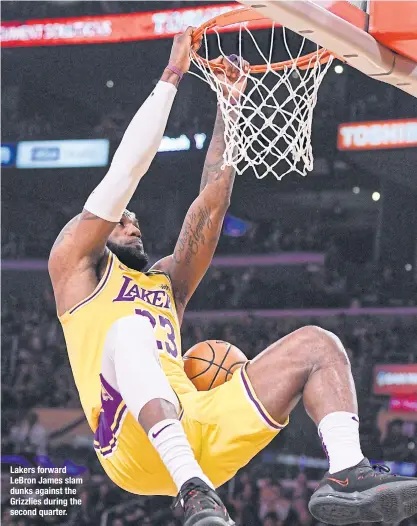  ??  ?? Lakers forward LeBron James slam dunks against the Grizzlies during the second quarter.