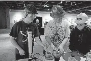  ??  ?? A Pawnee Middle School team of, from left, Serynity Rothun, K.J. Stewart and Beau Dominey attempt to seal off the oil reservoir from which they worked to pump out the oil in competitio­n Tuesday during the 2018 Oklahoma Engineerin­g Foundation...