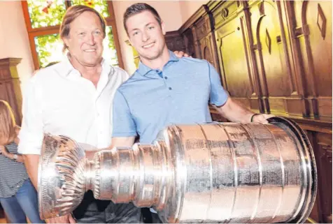  ?? Foto: Peter Kneffel, dpa ?? Fast jeder Eishockey-Spieler träumt davon, einmal den Stanley Cup in den Händen zu halten – den Pokal für den Sieger der nordamerik­anischen NHL. Tom Kühnhackl (rechts) gewann ihn mit den Pittsburgh Penguins und brachte ihn nun nach Bayern und zu seinem...